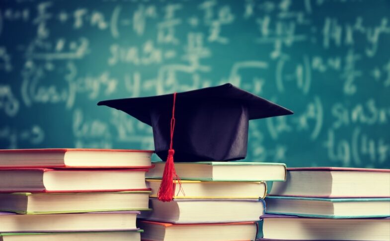 Böcker i hög och studentmössa