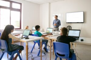 Klassrum med lärare och elver med datorer