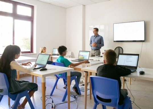 Klassrum med lärare och elver med datorer
